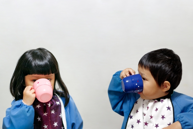 コップでお茶を飲む子ども